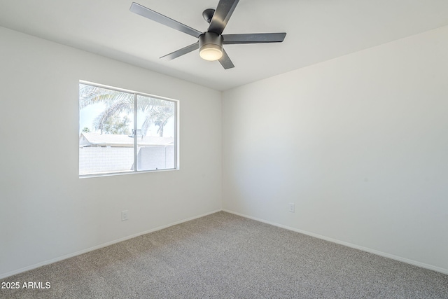 carpeted empty room featuring ceiling fan and baseboards