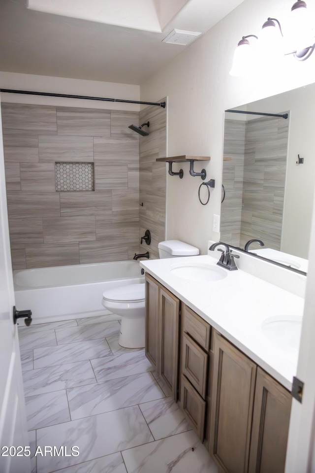 full bathroom featuring marble finish floor, double vanity, shower / bath combination, toilet, and a sink