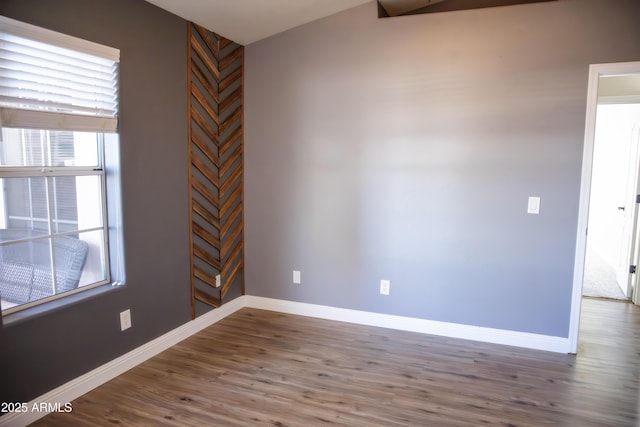 empty room with baseboards and wood finished floors