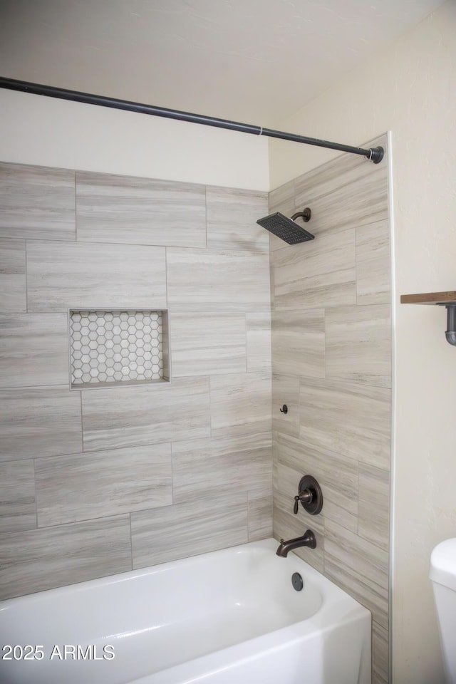 bathroom featuring bathing tub / shower combination and toilet