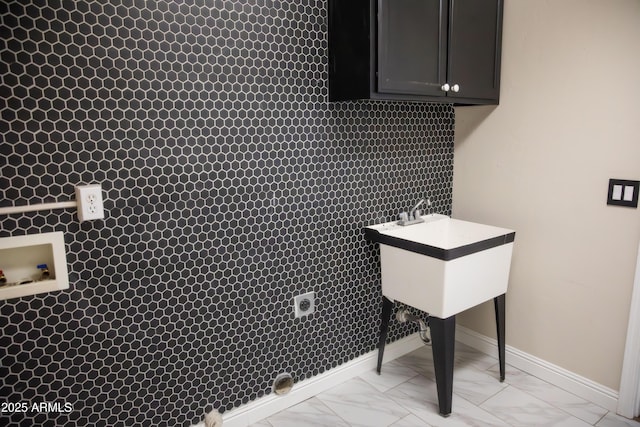 washroom with marble finish floor, cabinet space, baseboards, and hookup for an electric dryer