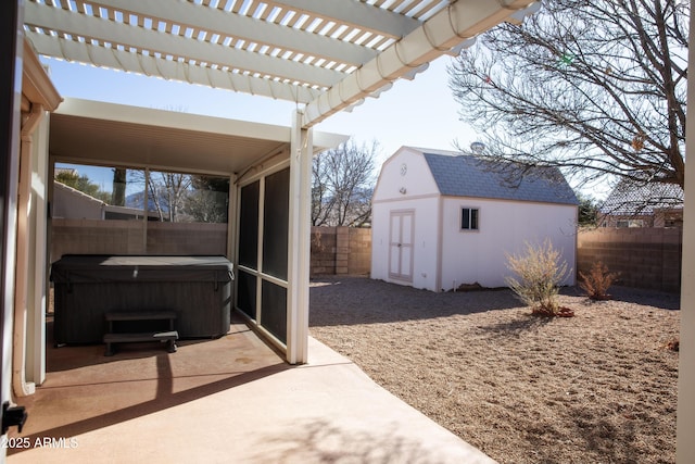 view of patio featuring a hot tub, a fenced backyard, an outbuilding, a storage unit, and a pergola