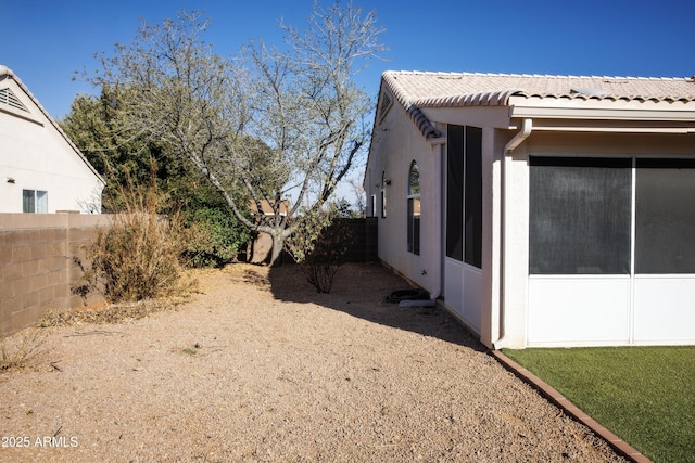 view of home's exterior with a fenced backyard, a tiled roof, and stucco siding