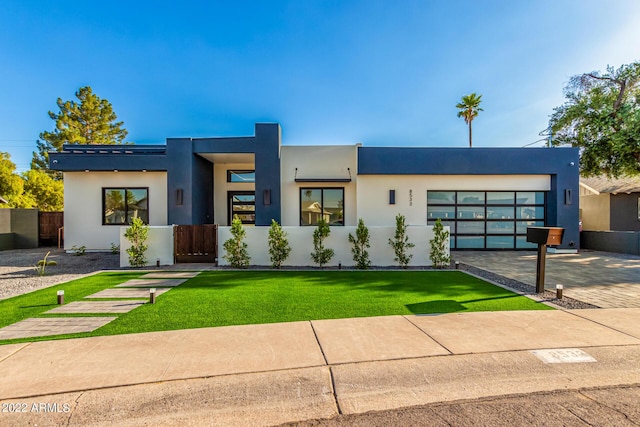 modern home featuring a garage and a front lawn