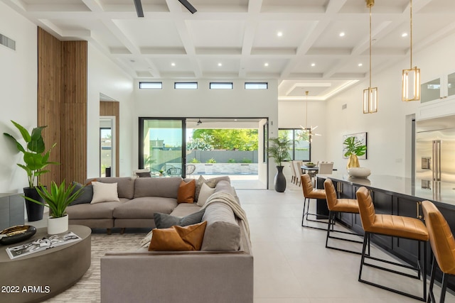 living room featuring beam ceiling, a towering ceiling, and coffered ceiling