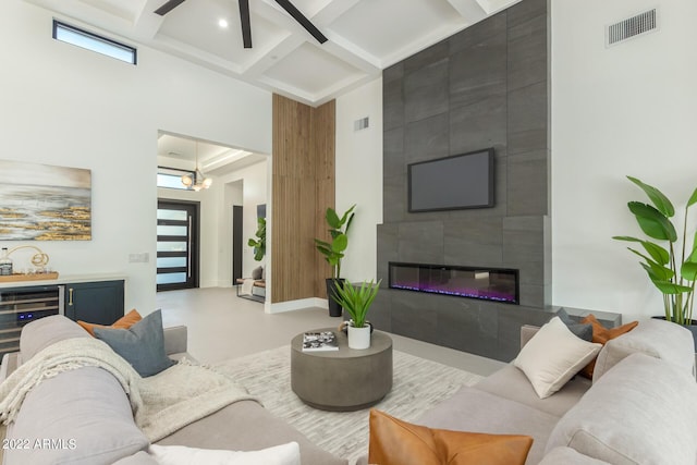 living room with a fireplace, concrete floors, ceiling fan with notable chandelier, and plenty of natural light