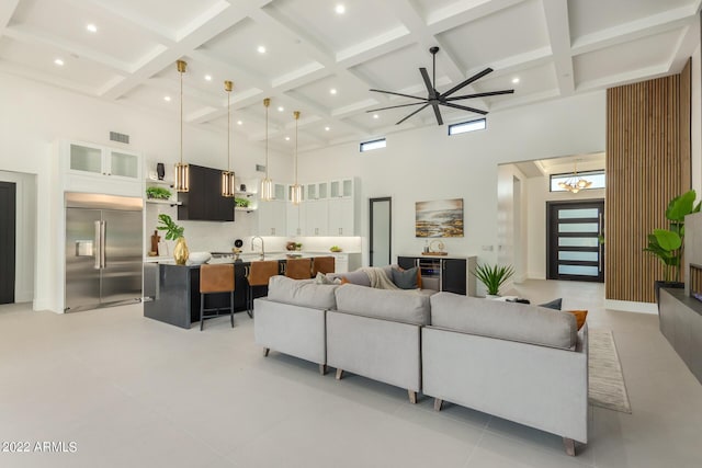 living room featuring ceiling fan, a towering ceiling, light tile patterned floors, and coffered ceiling