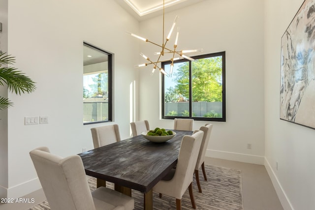 dining room with a high ceiling and an inviting chandelier