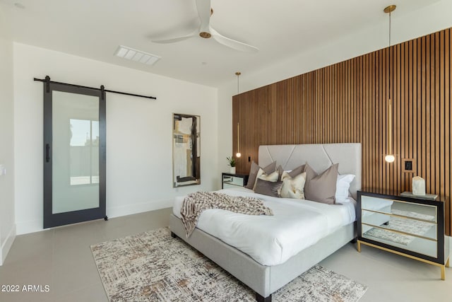 bedroom with a barn door and ceiling fan