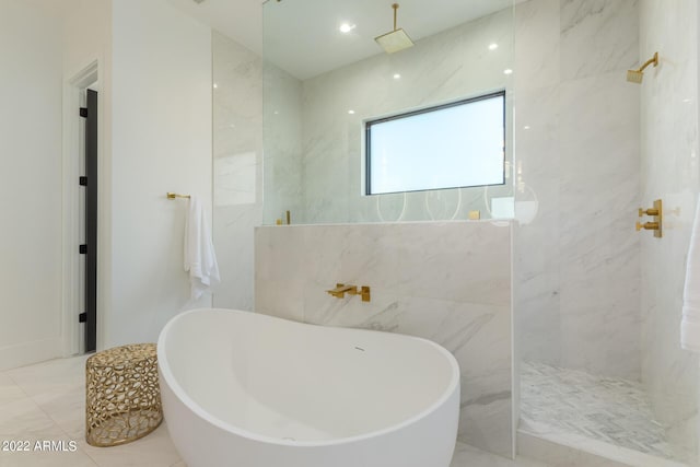 bathroom featuring plus walk in shower and tile walls