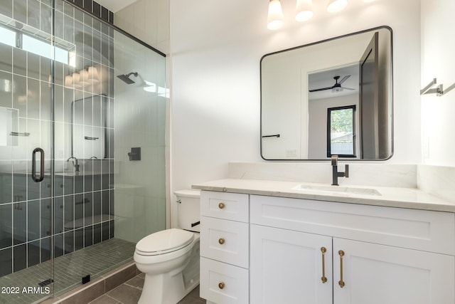 bathroom featuring ceiling fan, tile patterned floors, an enclosed shower, toilet, and vanity