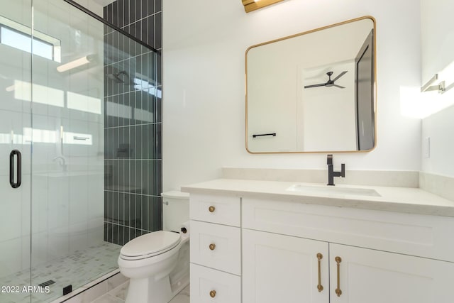 bathroom featuring ceiling fan, toilet, a shower with door, and vanity