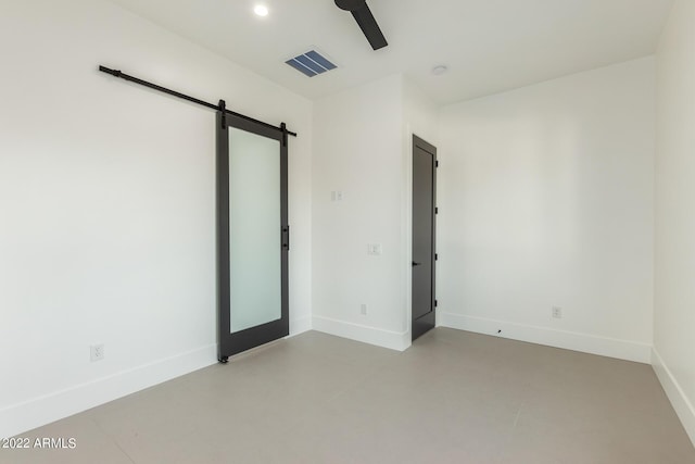 unfurnished room featuring a barn door