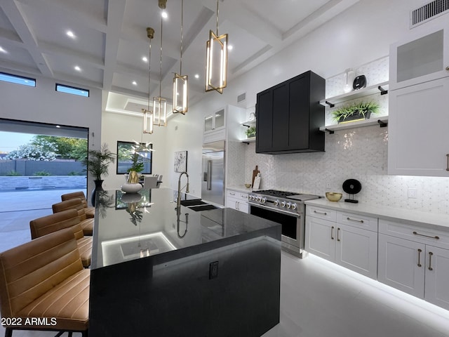 kitchen with white cabinets, pendant lighting, high end appliances, and coffered ceiling