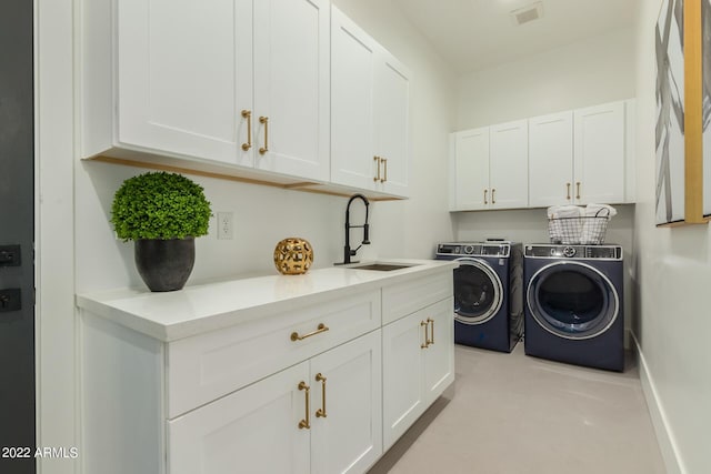 clothes washing area featuring cabinets, separate washer and dryer, and sink