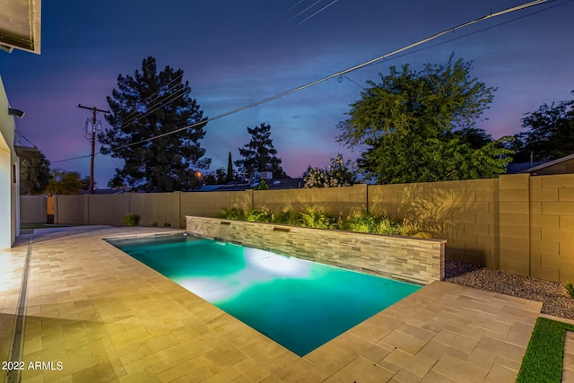 pool at dusk featuring a patio area