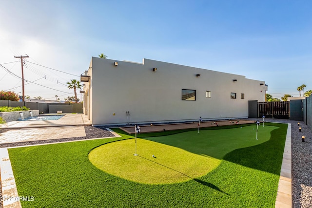 rear view of house with a fenced in pool and a patio