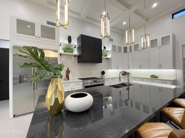 kitchen with coffered ceiling, white cabinets, sink, stainless steel stove, and beamed ceiling