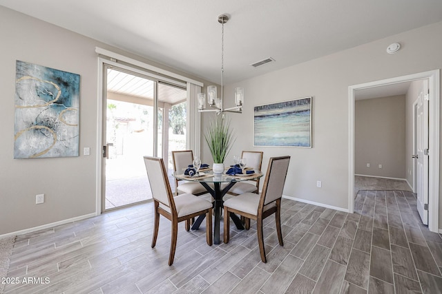 dining room featuring baseboards, visible vents, a chandelier, and wood finish floors