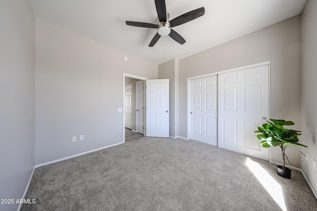 unfurnished bedroom with ceiling fan, a closet, baseboards, and carpet flooring