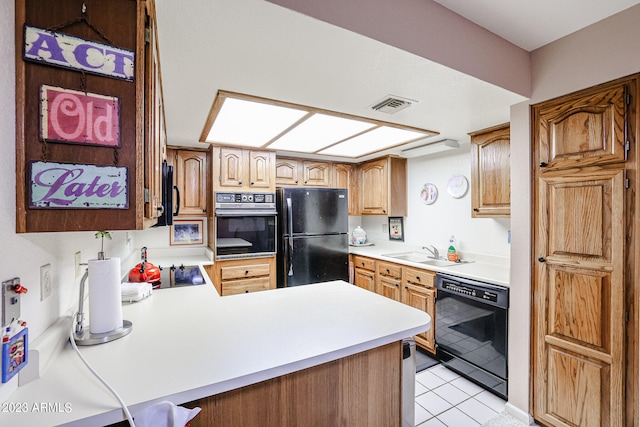 kitchen featuring kitchen peninsula, light tile floors, black appliances, and sink