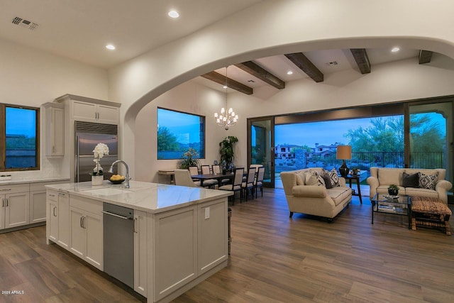 kitchen featuring stainless steel appliances, dark wood-type flooring, sink, and a center island with sink