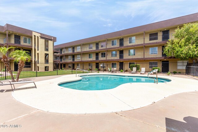 pool featuring fence and a patio area