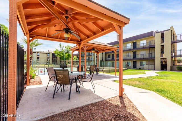 view of patio featuring fence, a ceiling fan, outdoor dining space, and a gazebo