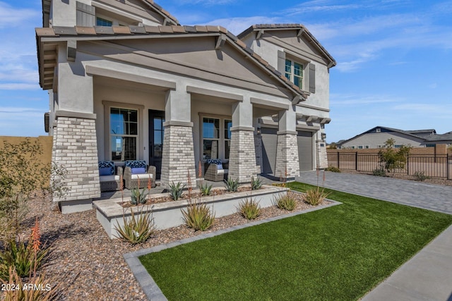 craftsman-style house with a front lawn, covered porch, and a garage