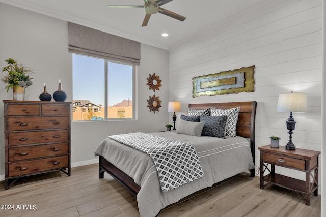 bedroom with ceiling fan, ornamental molding, and light hardwood / wood-style floors