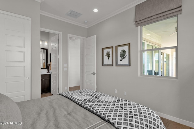 bedroom featuring hardwood / wood-style flooring, connected bathroom, and crown molding