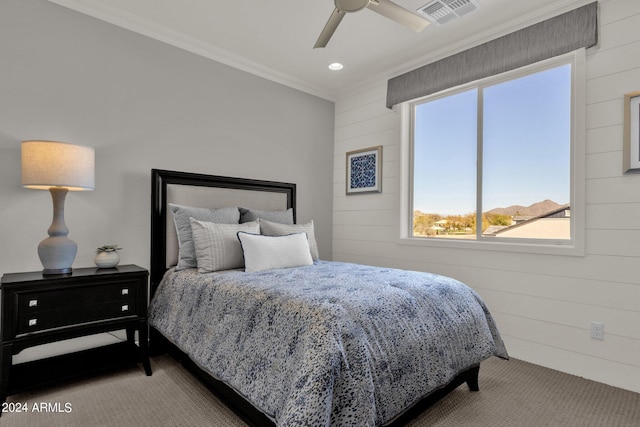 bedroom featuring ceiling fan, wood walls, and ornamental molding