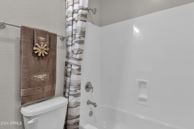 bathroom featuring toilet and shower / bath combination with curtain