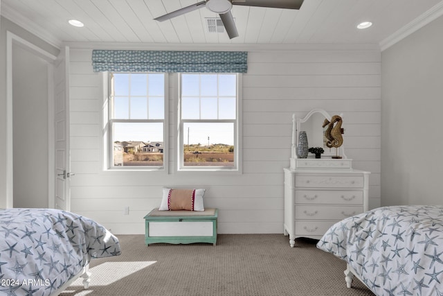 bedroom with wood walls, ceiling fan, crown molding, and carpet floors