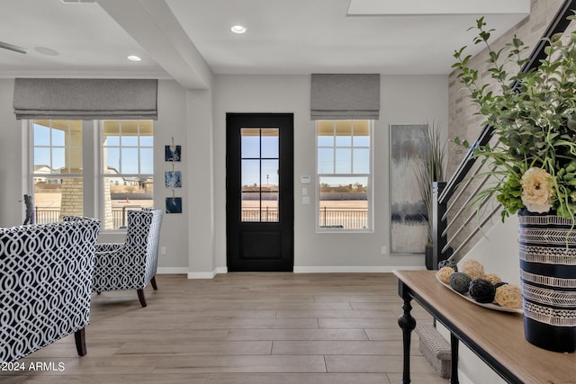 entryway featuring a water view, plenty of natural light, and light hardwood / wood-style flooring