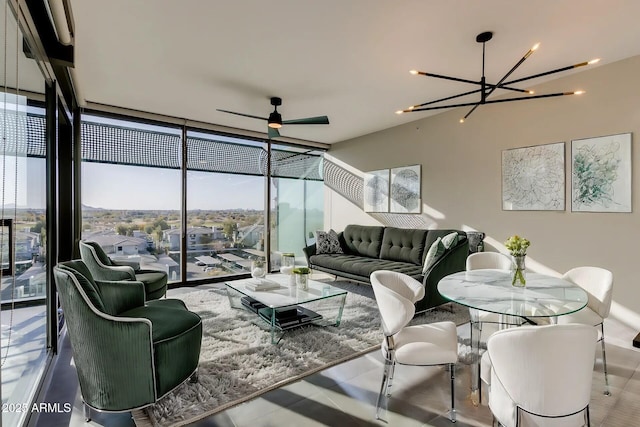 living room featuring floor to ceiling windows and ceiling fan with notable chandelier