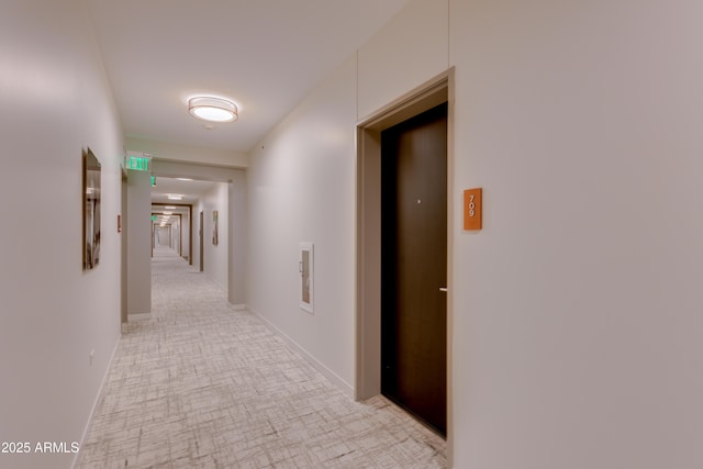 hall with elevator and baseboards