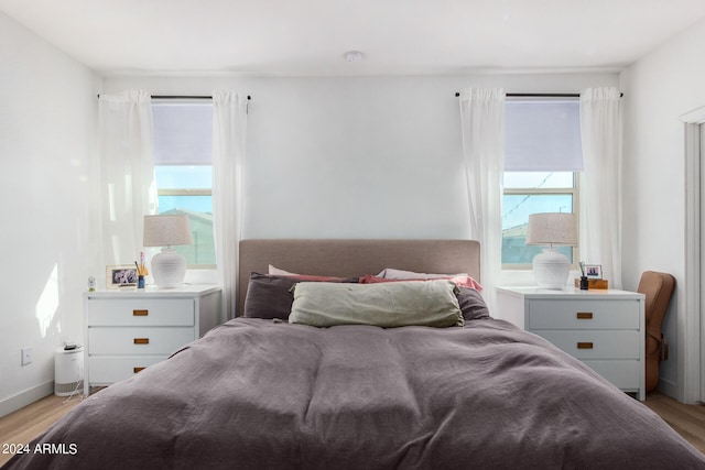 bedroom with multiple windows and light wood-type flooring