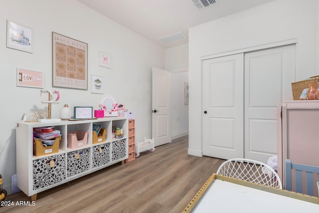 bedroom featuring a closet, wood finished floors, and visible vents
