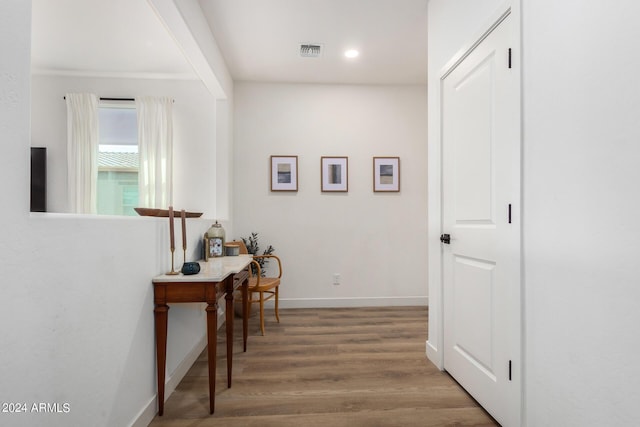corridor featuring baseboards, wood finished floors, visible vents, and recessed lighting