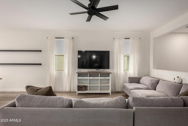 living area featuring baseboards, wood finished floors, and ceiling fan