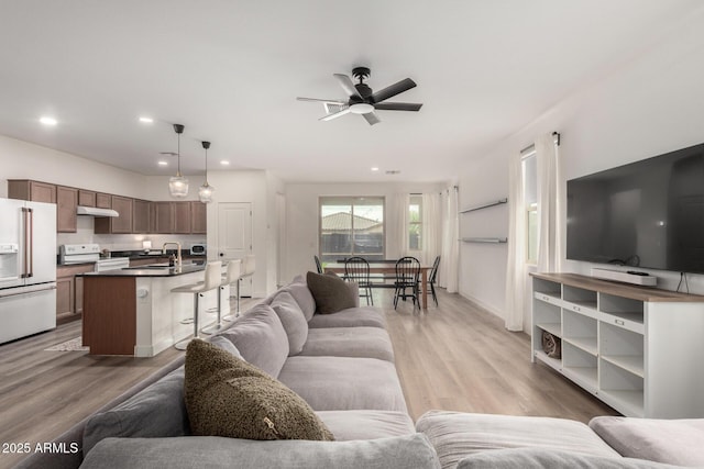 living area featuring recessed lighting, light wood-type flooring, and ceiling fan