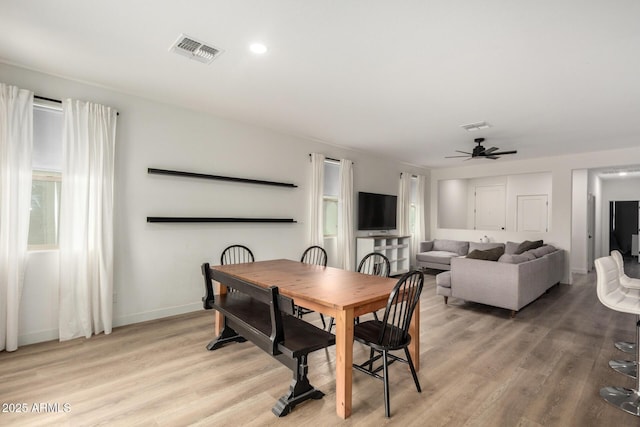 dining room with ceiling fan, baseboards, light wood finished floors, and visible vents