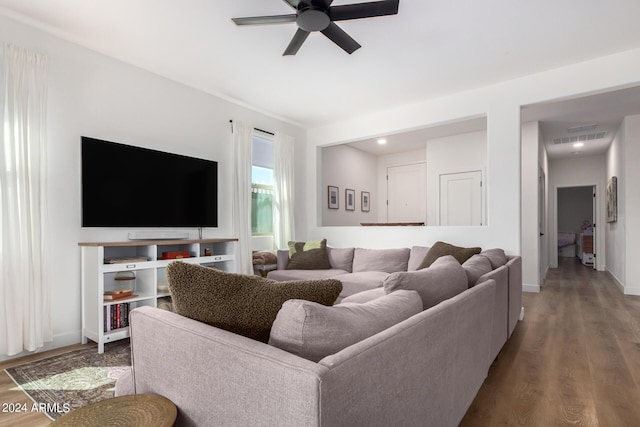 living room with wood finished floors, visible vents, baseboards, and ceiling fan