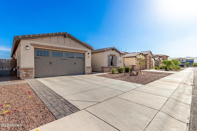 17311 W Seldon Ln, Waddell, AZ 85355 - view of front of property with stone siding, concrete driveway, stucco siding, and an attached garage