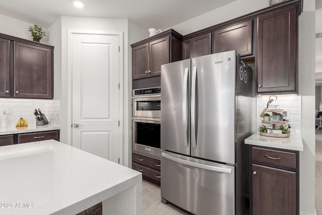 17311 W Seldon Ln, Waddell, AZ 85355 - kitchen featuring stainless steel appliances, dark brown cabinets, light countertops, backsplash, and recessed lighting