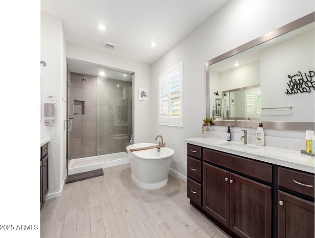 17311 W Seldon Ln, Waddell, AZ 85355 - bathroom with a stall shower, healthy amount of natural light, a freestanding tub, wood finished floors, and recessed lighting
