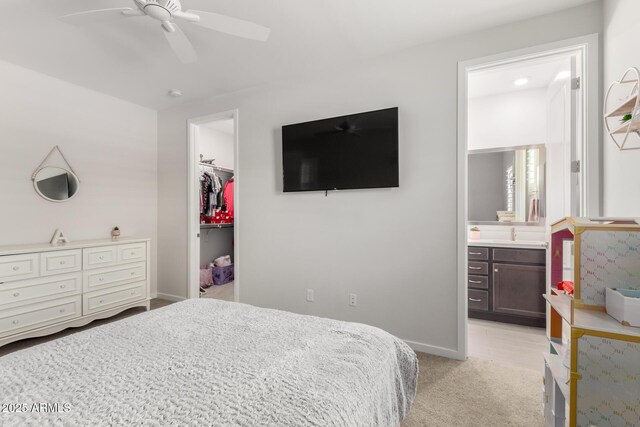 17311 W Seldon Ln, Waddell, AZ 85355 - bedroom with a walk in closet, light carpet, a closet, ensuite bath, and baseboards