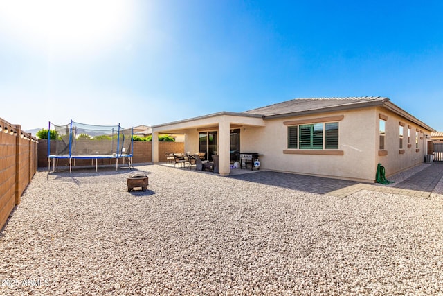 17311 W Seldon Ln, Waddell, AZ 85355 - rear view of house featuring a trampoline, stucco siding, a fenced backyard, and a patio