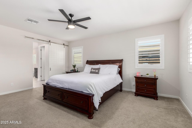 17311 W Seldon Ln, Waddell, AZ 85355 - bedroom with a barn door, baseboards, ceiling fan, and light carpet